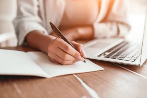 Femme indépendante en train de réfléchir à sa communication et noter ses idées